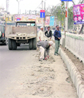 MC employees collect debris from a road in front of the Panjab University Extension Library in Ludhiana