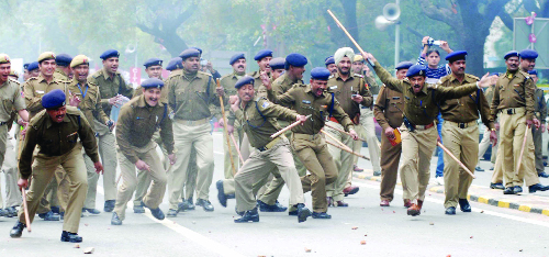 The police chases away the activists at Parliament Street in New Delhi on Thursday.