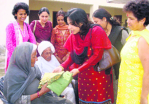 Ashima Sabharwal, chairperson of the AFWWA, along with other members, offers clothes to senior citizens at Sirsa on Thursday. Photo: Amit Soni