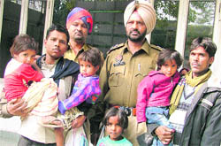Police officials pose with the four girls and their respective parents in Ludhiana on Thursday.