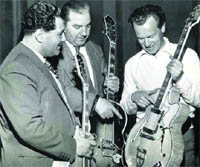 Ike Isaacs plays the guitar along with two fellow guitarists during a break in his recording session in 1959.