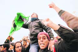 Libyans shout slogans against Muammar Gaddafi after the Friday prayers outside the courthouse in Benghazi. 