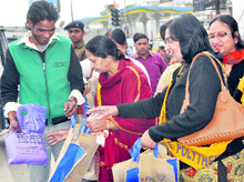 Members of the Vaish Ladies Club distribute cloth bags in Dehradun on Saturday