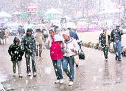 Tourists enjoy snowfall in Manali on Saturday