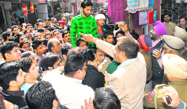 Shopkeepers argue with the police officials over the deteriorating law and order situation in Jalandhar.