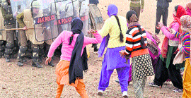 Police personnel trained to deal with stone throwing in action during a mock exercise at the Armed Police Training Centre at Sunjwan in Jammu on Saturday.