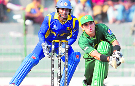 Pakistans Misbah-ul-Haq (R) hits a shot as Sri Lankas Kumar Sangakkara looks on in Colombo on Saturday.