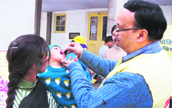 A member of the Rotary Club administers polio drops to a child at Mussoorie on Sunday.