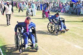 Girls participate in a wheelchair race at the state-level games for children with special needs at Dronacharya Stadium in Kurukshetra