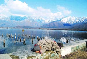 A man takes a nap on the banks of the Dal Lake in Srinagar on Sunday.