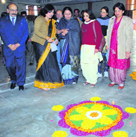 Sumita Roy and college staff membersF have a look at a rangoli.