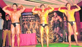Participants flex muscles during a bodybuilding championship in Jammu