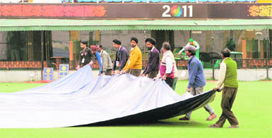 With Met officials predicting rain, grounds men cover the ground at the PCA stadium in Mohali on Wednesday.