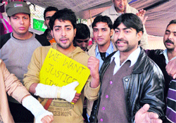 Physiotherapists show fractured arms at a press conference in the Mubarak Mandi complex in Jammu on Wednesday