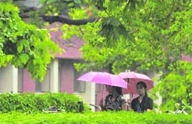 CHILL IN THE AIR: Girls protect themselves from rain in Ludhiana