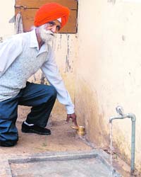 Balbir Singh, a resident of Railon Khurd village in Ropar district, points to the water meter installed in a house