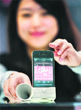 A woman displays an iPhone horn speaker as the display of the device reads the word "love" at the CeBIT, the world's biggest IT fair, on Thursday in Hanover, Germany. More than 4,200 tech firms from 70 countries are expected to attend this year's CeBIT. The fair is running until March 5