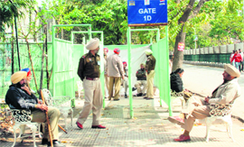 Sitting Pretty: Police personnel relax in the sun as they await fans.