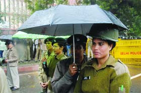 Police officials caught in the rain in New Delhi on Thursday