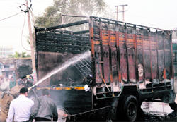 Firefighters try to douse the fire after it engulfed a truck near the Jalandhar bypass in Ludhiana