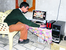 Herculean Singh, a student, plays a video game on his computer in Shimrewala village in Faridkot district