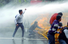 The police uses water cannons to disperse activists of the Delhi Bharatiya Janata Yuva Morcha during a protest in front of the AICC office against price rise and corruption in New Delhi on Friday.