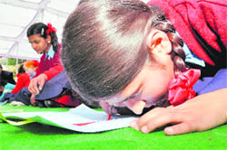 A visually challenged student does a painting at the Raj Bhawan, Dehradun, on Friday.