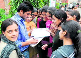 CWG boxing gold medallist Manoj Kumar gives autographs to girls at the annual athletic meet of KVA DAV College for Women in Karnal on Friday.