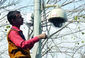 A worker places a CCTV camera at Jantar Mantar in New Delhi