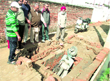 Residents point towards the open manhole, which became the cause of an accident at Vikas Nagar.