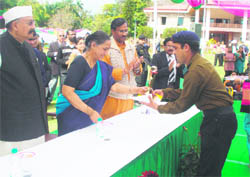 Governor Margaret Alva gives away a prize to a winner at the Raj Bhawan in Dehradun on Sunday. 