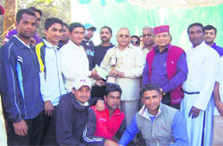 Assembly Speaker Harbans Kapoor presents the winning team with the Uttarakhand Twenty20 Cricket League Championship trophy at the Mahendra Grounds in Dehradun on Sunday. 