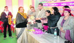 Dr Abha Shaili receives an award on the eve of International Womens Day from Usha Rawat in Mussoorie on Monday.