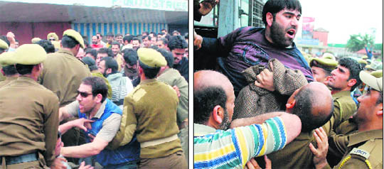 Members of the Jammu and Kashmir Government Employees Joint Consultative Committee scuffle with the police during a rally in Jammu on Monday; and (right) a protesting employee being detained by the police.
