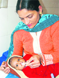 A nurse at a hospital in Amritsar feeds a girl child who was abandoned in a panghuraput up by the district administration.
