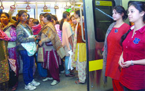 Lady volunteers of the Metro Citizens Forum counsel male commuters against entering the coaches for women at Central Secretariat Metro Station in New Delhi on Tuesday.