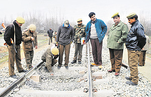 Security personnel inspect the damaged railway track at Nowgam near Srinagar on Tuesday. Photo: Amin War