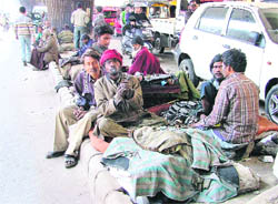 Persons seeking alms line up under the elevated bridge at Mata Rani chowk, near the MC office, in Ludhiana. 