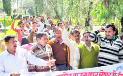 Teachers of unaided private schools hold a protest at the Gandhi Park in Dehradun