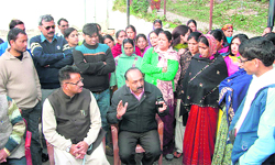 Rajpur MLA Ganesh Joshi and owner of a part of the Hakmans compound Girish Dhaundiyal with affected families in Mussoorie