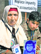 A woman and a boy hold a photograph of their missing relative during a protest in Srinagar