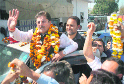 GS Charak waves at party workers outside the Jammu Airport 