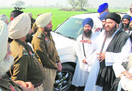 Sant Baljeet Singh Daduwal talks to a police official before the former was rounded up from Gurdwara Jandalisar on the Bathinda-Talwandi Sabo road on Thursday.