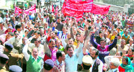 Employees of the Uttarakhand Jal Nigam and Jal Sansthan take out a procession in front of the residence of the Uttarakhand Chief Minister in Dehradun on Thursday.