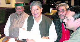 Mussoorie Hotel Association spokesperson Sandeep Sahni presnts a memorandum to Union Minister of State for Agriculture and Food Processing Industries Harish Rawat in Mussoorie on Friday.