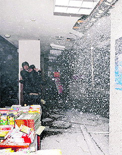 People take shelter as a ceiling collapses in a bookstore in Sendai, northeastern Japan.