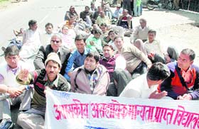Members of the Ashaskiya Asahyak Manyata Prapt Vidyalaya Sangathan protest in Dehradun