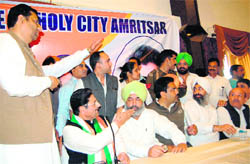 Gulchain Singh Charak, in charge of Punjab Congress affairs, tries to pacify party men prior to a press conference in Amritsar on Saturday.