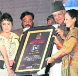 Meghna Malik, a TV artiste, receives an award from Union Minister Farooq Abdullah during a HIFA awards function in Karnal on Sunday.