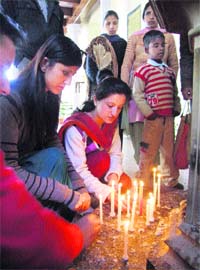 People pray for the earthquake and Tsunami victims of Japan by lighting candles at Christ Church in Shimla